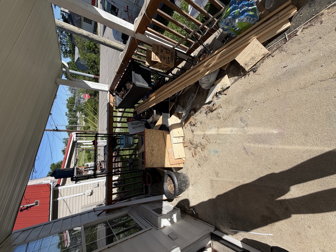 A porch and concrete pad stacked with old lumber and debris before a haul off in Richmond, Kentucky.