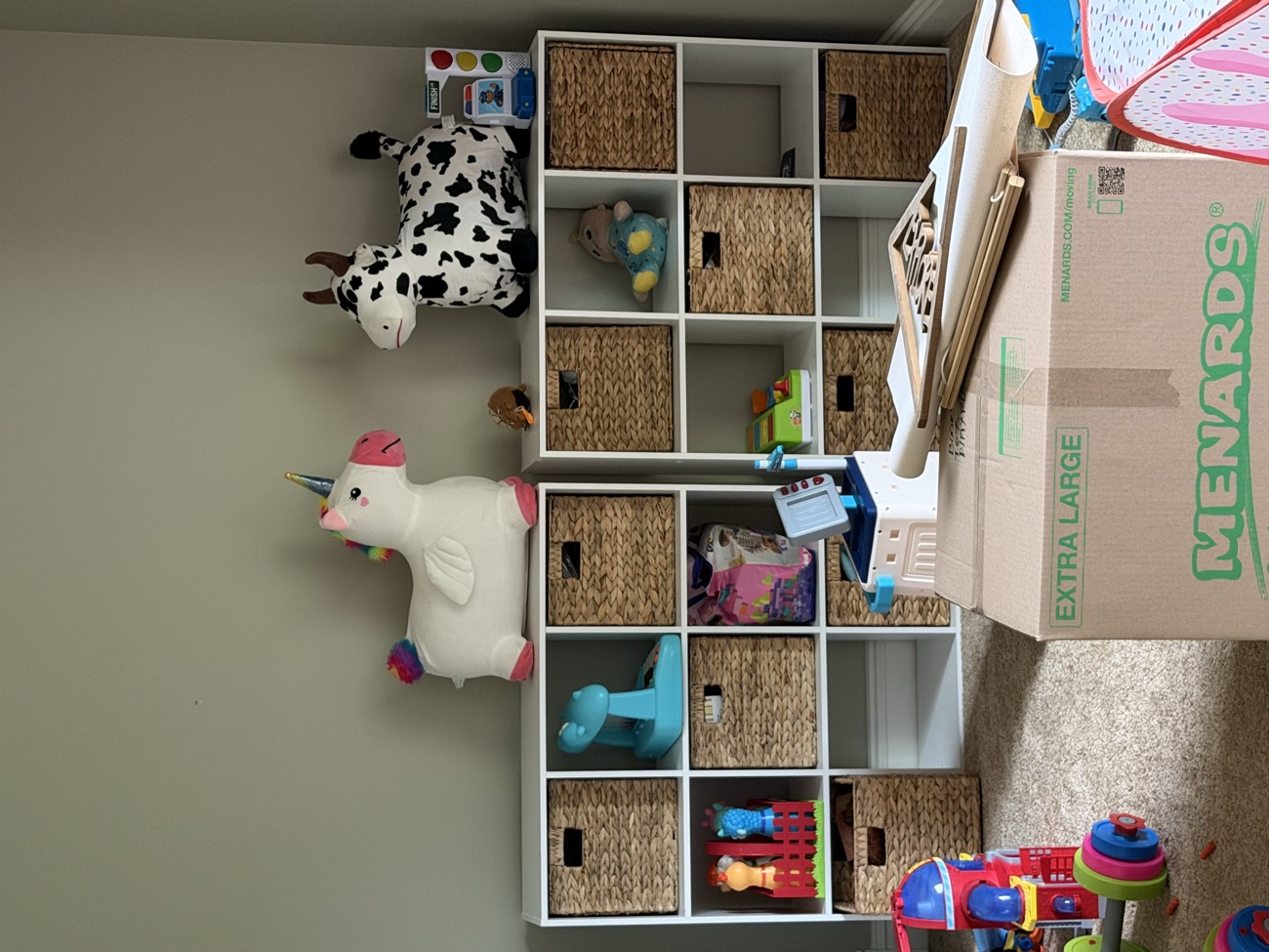 A kids playroom packed with toys, shelving, and boxes before removal.
