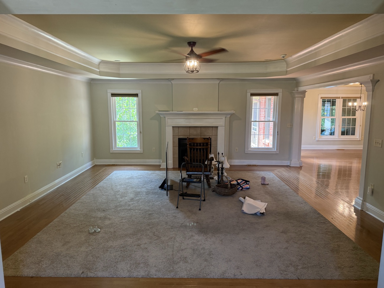 A spacious living room with a fireplace left empty and swept after a cleanout.