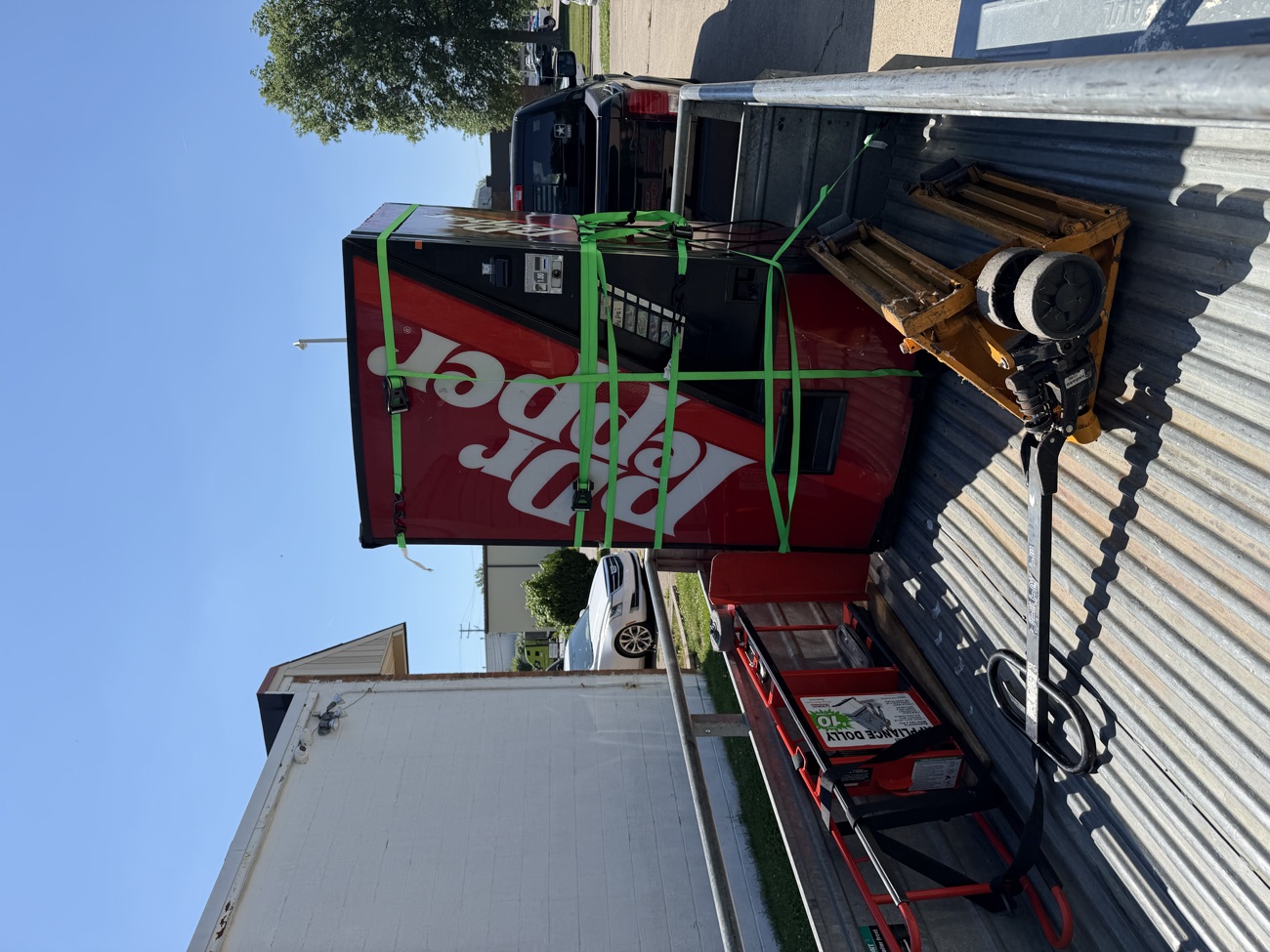 A full size vending machine strapped down and hauled away.
